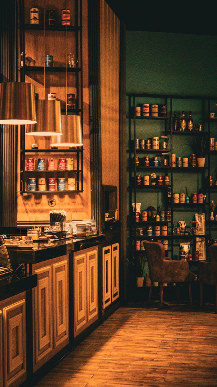 Warm and inviting cafe interior featuring wooden decor, shelves with jars, and cozy lighting.