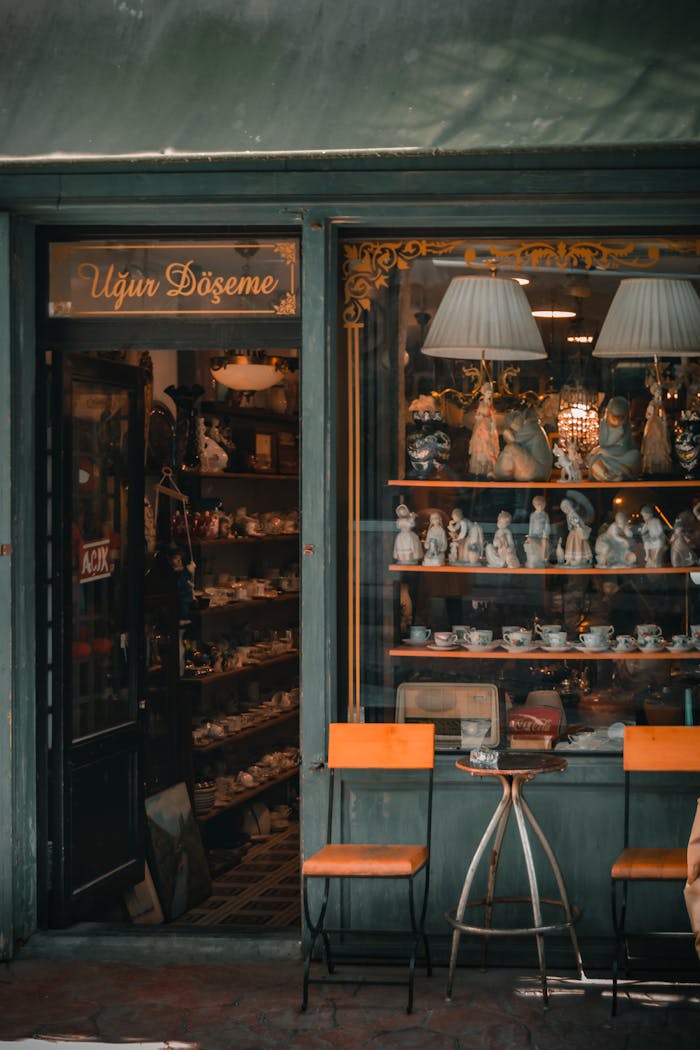 Charming vintage storefront with porcelain figurines and antique furniture displayed, exuding an old-world charm.